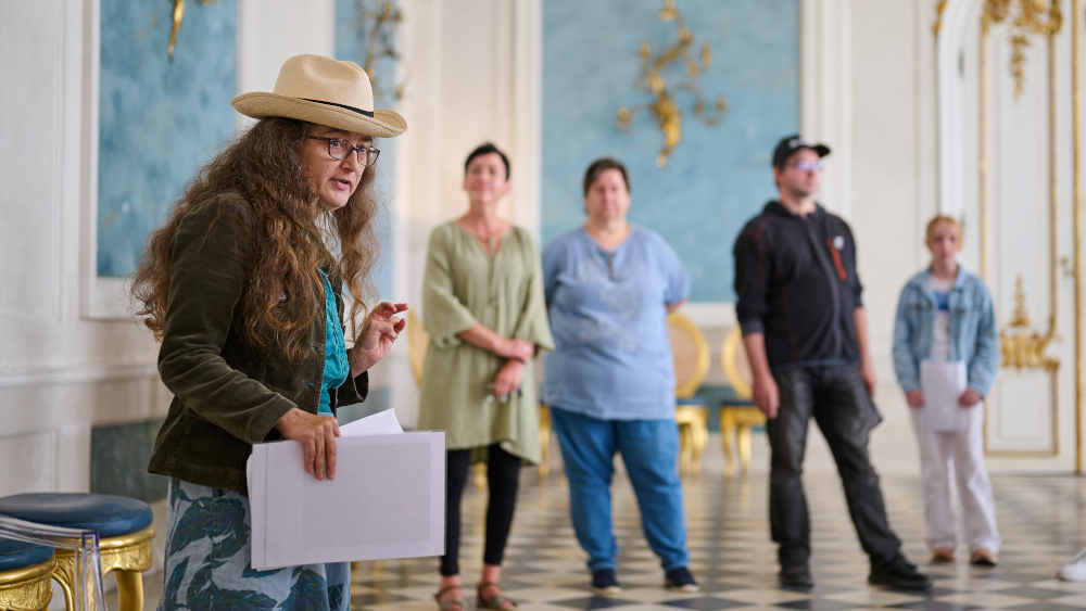 Beschäftigte der Potsdamer Oberlin-Werkstätten führen im Schloss Neue Kammern im Park Sanssouci in Potsdam Gäste durch die prunkvollen Räume