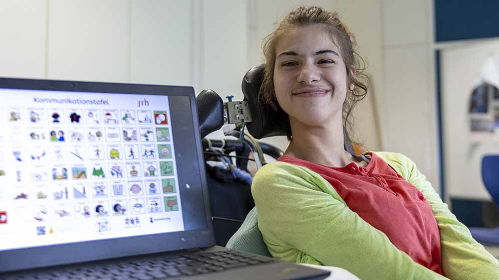 Tabea sitzt im Rollstuhl und spricht ueber einen Sprachcomputer. Im Team mit Mitschülerinnen und Mitschülern hat sie den Pilgerweg "Camino Incluso" entwickelt