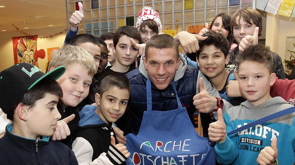 Prominenter Besuch: Im Dezember 2012 schaut Fußballer Lukas Podolski bei der Arche in Köln vorbei