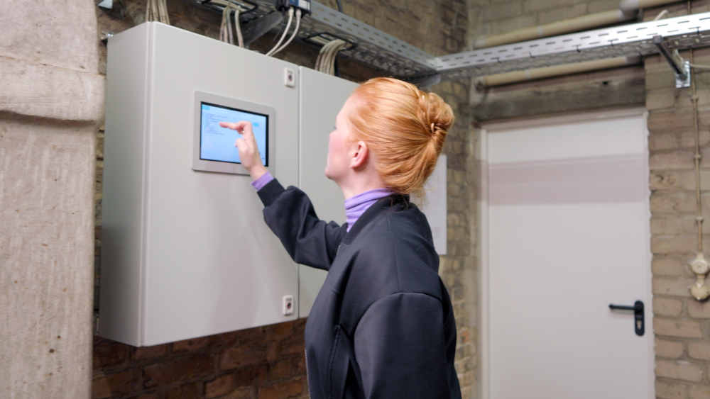 Im Keller der Apostel-Paulus-Kirche steht Ajna Nickau an der Steuerung der Heizungsanlage