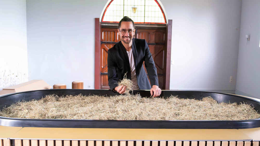 Der Geschäftsführer von "Meine Erde", Pablo Metz, steht in der Kapelle auf dem Parkfriedhof Eichhof in Kiel hinter dem Kokon, in dem seit Frühjahr 2023 Reerdigungen stattfinden