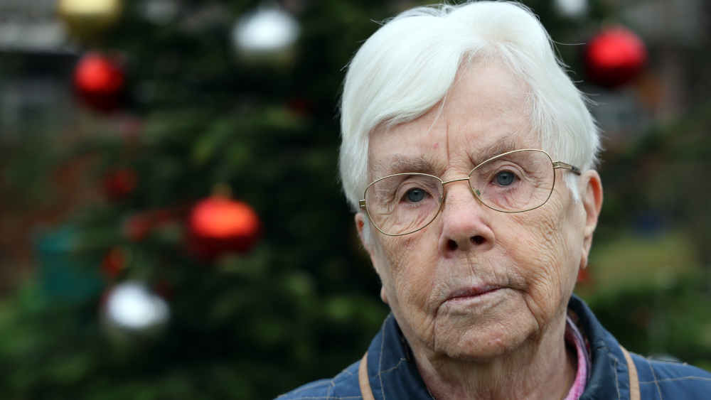 Sigrid König steht vor dem Tannenbaum im Garten ihrer Wohnanlage in Bremen
