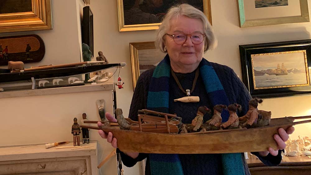 Die Pastorin zeigt ein geschnitztes Holzboot aus ihrer Sammlung