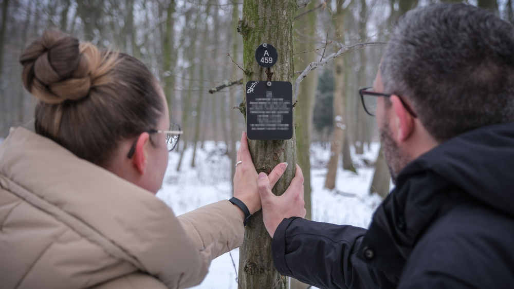 Rebekka R. und ihr Mann Christoph G. stehen am Grab ihrer verstorbenen Tochter Johanna im Friedwald "Waldbestattung Cremlinger Horn"